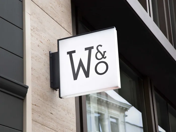 A square W&O sign on a stone facade